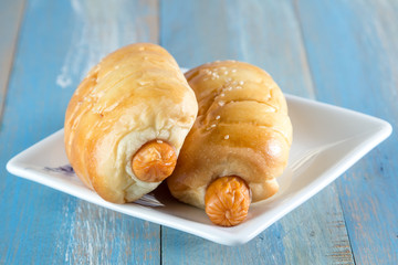 Bread with Sausage in dish on wooden