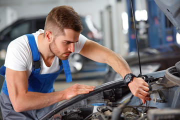 Portrait of a mechanic about to repair a car's engine 