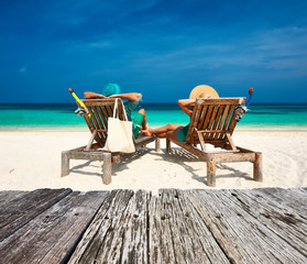 Couple in green relax on a beach at Maldives