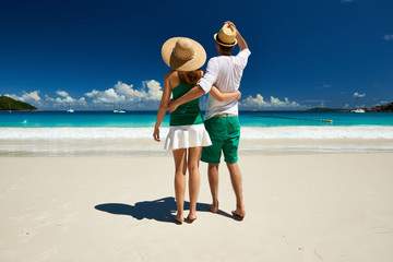 Couple in green walking on a beach at Seychelles