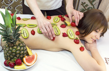 Obraz na płótnie Canvas fruity young girl doing a massage in the beauty salon