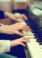 Fototapeta premium Woman teaching little girl to play the piano.