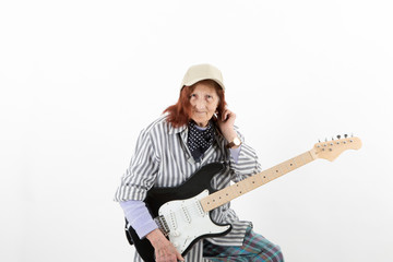 Funny elderly lady playing electric guitar.