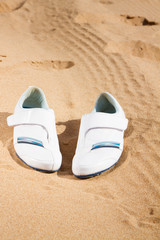 Fototapeta na wymiar white sneakers in sand 