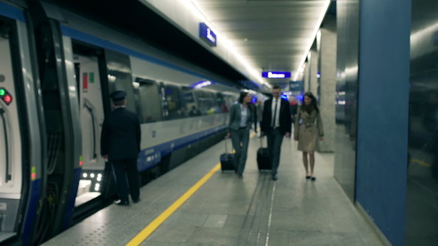 Happy businesspeople walking on the train station, steadycam shot
