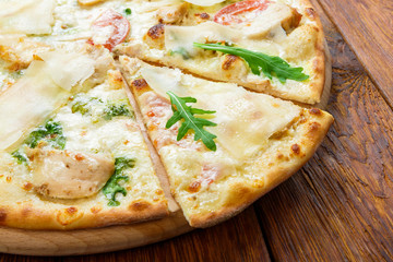 Delicious pizza with chicken, parmesan and fresh arugula