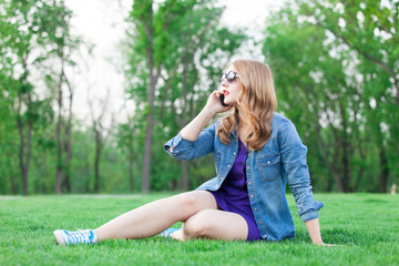 Girl with mobile phone on grass