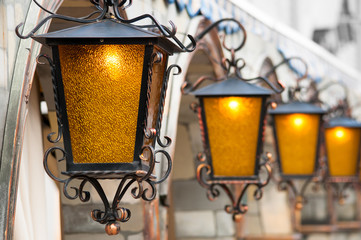 Four brass lanterns hanging on arc facade 
