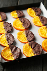 Fototapeta na wymiar Delicious slices of orange coated chocolate on pan