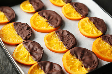 Delicious slices of orange coated chocolate on pan