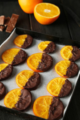 Delicious slices of orange coated chocolate on pan