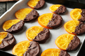Delicious slices of orange coated chocolate on pan