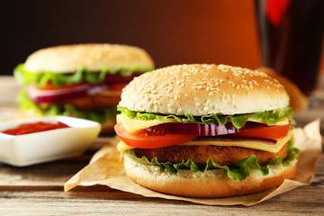 Fresh burgers on brown wooden background