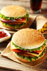 Fresh burgers on brown wooden background