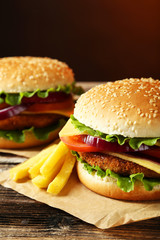 Fresh burgers on brown wooden background