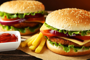 Fresh burgers on brown wooden background