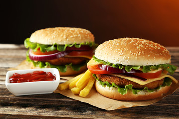 Fresh burgers on brown wooden background