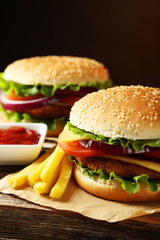 Fresh burgers on brown wooden background