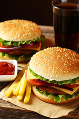 Fresh burgers on brown wooden background