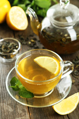 Cup with green tea on wooden background