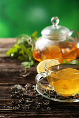 Cup with green tea and teapot 