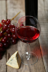Glass of red and white wine, cheeses and grapes 