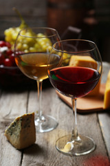 Glass of red and white wine, cheeses and grapes 