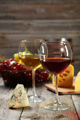 Glass of red and white wine, cheeses and grapes 