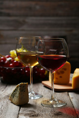 Glass of red and white wine, cheeses and grapes 