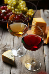 Glass of red and white wine, cheeses and grapes 