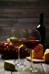 Glass of red and white wine, cheeses and grapes 