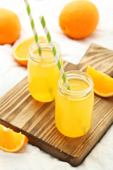 Fototapeta na wymiar Glass of fresh orange juice on wooden background