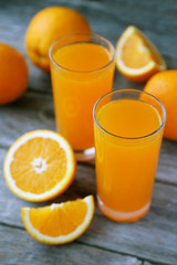 Glass of fresh orange juice on wooden background