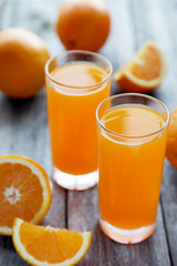 Glass of fresh orange juice on wooden background