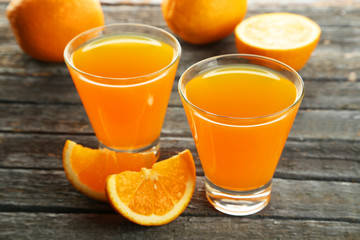 Glass of fresh orange juice on wooden background