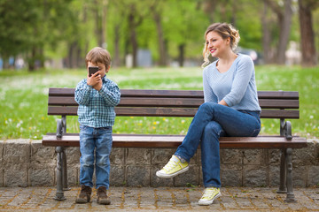 Fototapeta premium Cute little boy playing with mobile phone