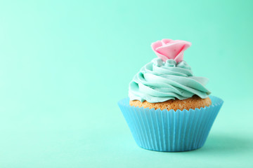 Tasty cupcake on green background