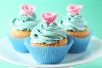 Tasty cupcake on green background