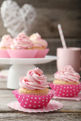 Tasty cupcake on grey wooden background