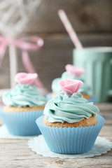 Tasty cupcake on grey wooden background