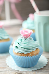 Tasty cupcake on grey wooden background