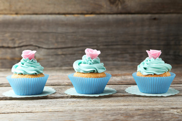 Tasty cupcake on grey wooden background
