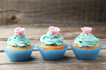 Tasty cupcake on grey wooden background