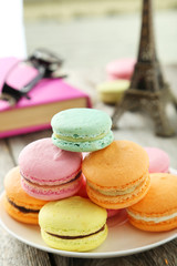 Fototapeta na wymiar French colorful macarons on plate on grey wooden background