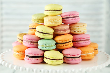 Fototapeta na wymiar French colorful macarons on cake stand on white wooden backgroun