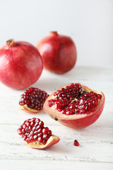 Delicious pomegranate fruit on white wooden background