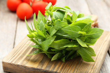 Basil leaves on grey wooden background