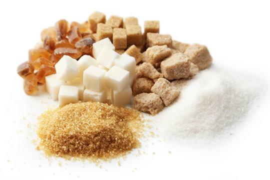 Brown sugar in spoon and bowl on wooden background