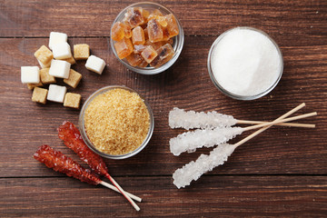 Brown sugar in spoon and bowl on wooden background