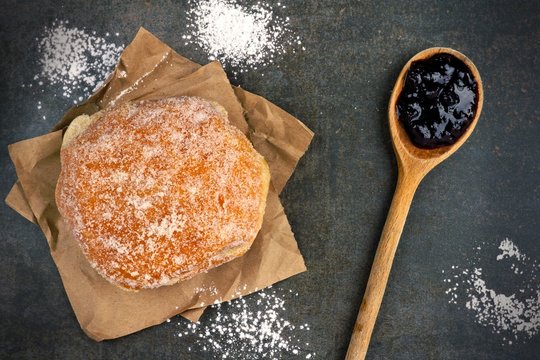 Sweet jelly filled donut on a vintage baking sheet
